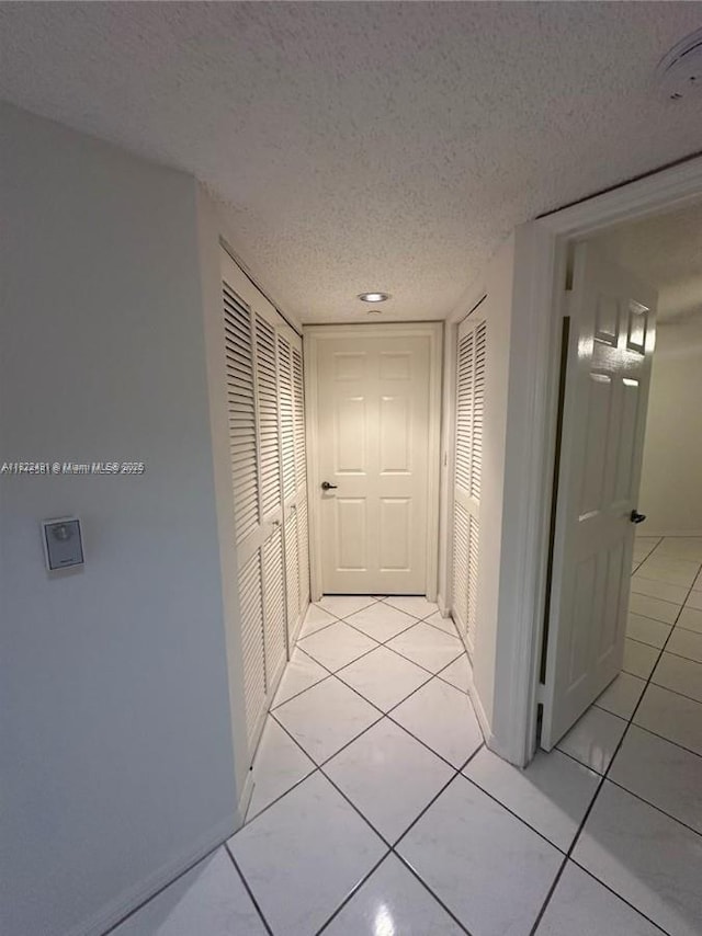 9587 Weldon Cir Unit B203, Tamarac, FL 33321 - hall featuring a textured ceiling and light tile patterned floors