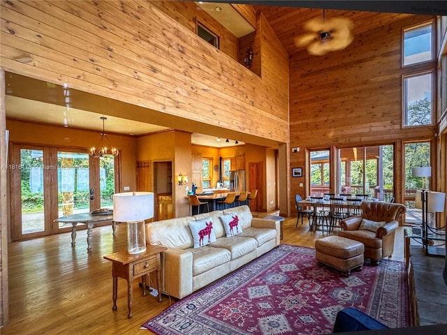 200 Summit Lodge Rd, Nc, NC 28604 - living room featuring a towering ceiling, plenty of natural light, a chandelier, wooden walls, and wood finished floors