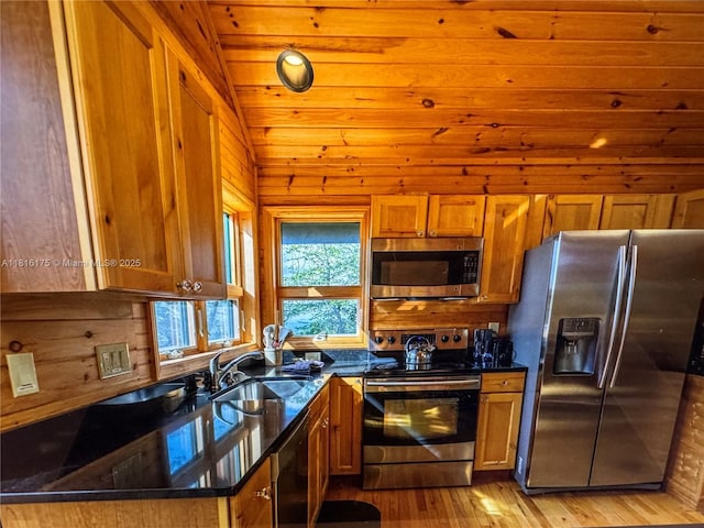 200 Summit Lodge Rd, Nc, NC 28604 - kitchen with appliances with stainless steel finishes, brown cabinets, wood walls, and light wood-style floors