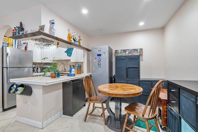 3032 Coral Ridge Dr Unit 217C, Coral Springs, FL 33065 - kitchen with freestanding refrigerator, decorative backsplash, a peninsula, light tile patterned floors, and recessed lighting