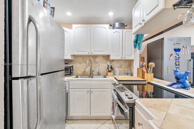 3032 Coral Ridge Dr Unit 217C, Coral Springs, FL 33065 - kitchen featuring freestanding refrigerator, electric stove, light tile patterned floors, white cabinets, and recessed lighting