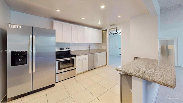 11111 Biscayne Blvd Unit 2G, Miami, FL 33181 - kitchen with appliances with stainless steel finishes, light tile patterned floors, white cabinets, and recessed lighting
