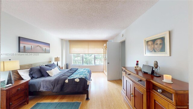 11111 Biscayne Blvd Unit 2G, Miami, FL 33181 - bedroom featuring light wood-style flooring and a textured ceiling