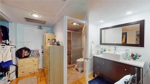 11111 Biscayne Blvd Unit 2G, Miami, FL 33181 - bathroom featuring a textured ceiling, a stall shower, vanity, wood finished floors, and recessed lighting