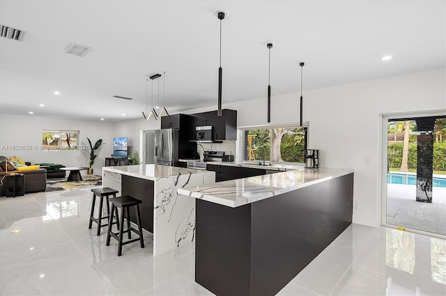 10361 SW 119th St, Miami, FL 33176 - kitchen featuring dark cabinets, stainless steel appliances, modern cabinets, a kitchen bar, and hanging light fixtures