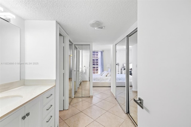 3731 N Country Club Dr Unit 2023, Aventura, FL 33180 - ensuite bathroom featuring vanity, a textured ceiling, and tile patterned floors