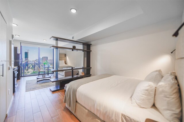 398 NE 5th St Unit 2407, Miami, FL 33132 - bedroom with floor to ceiling windows, wood finished floors, a barn door, recessed lighting, and a city view
