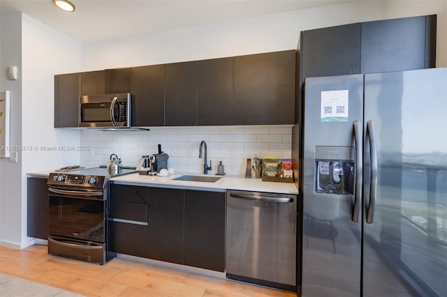 398 NE 5th St Unit 2407, Miami, FL 33132 - kitchen with appliances with stainless steel finishes, decorative backsplash, light countertops, modern cabinets, and light wood-style floors