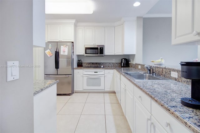 21025 NE 31st Ave, Aventura, FL 33180 - kitchen featuring stainless steel appliances, white cabinetry, light stone counters, light tile patterned floors, and recessed lighting