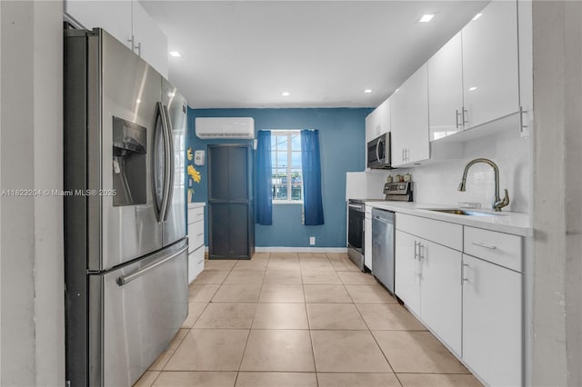 117 Ronald Rd, West Park, FL 33023 - kitchen with appliances with stainless steel finishes, a wall mounted AC, light countertops, white cabinets, and light tile patterned floors