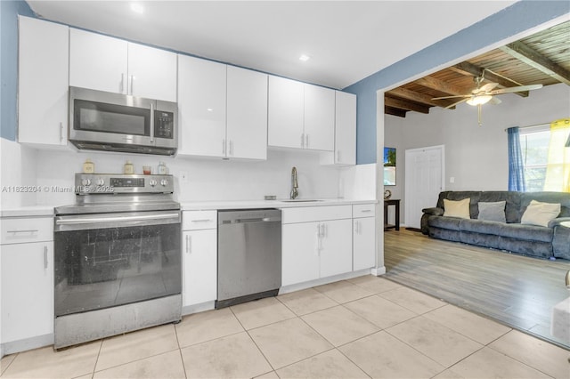 117 Ronald Rd, West Park, FL 33023 - kitchen featuring appliances with stainless steel finishes, light countertops, light tile patterned floors, a ceiling fan, and white cabinetry