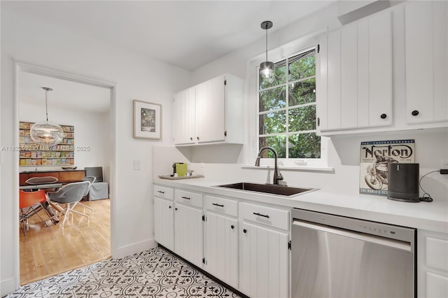 842 NW 9th Ct, Miami, FL 33136 - kitchen with stainless steel dishwasher, light countertops, white cabinets, and pendant lighting