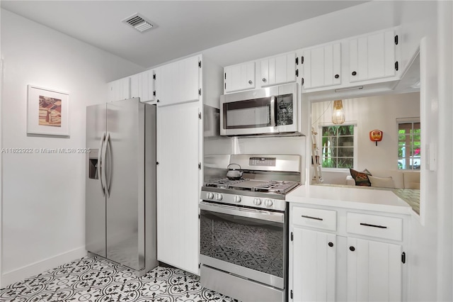 842 NW 9th Ct, Miami, FL 33136 - kitchen with appliances with stainless steel finishes, light countertops, white cabinets, and light tile patterned flooring