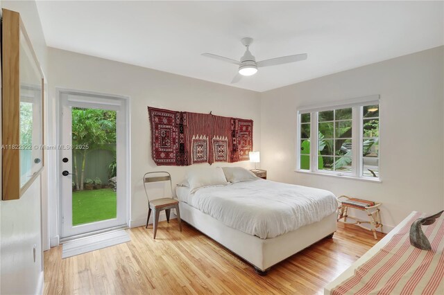 842 NW 9th Ct, Miami, FL 33136 - bedroom with multiple windows, access to exterior, wood finished floors, and a ceiling fan