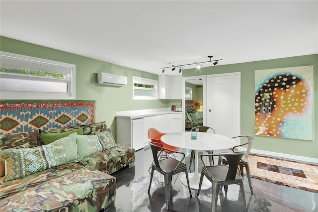 842 NW 9th Ct, Miami, FL 33136 - dining room featuring an AC wall unit, rail lighting, and finished concrete floors