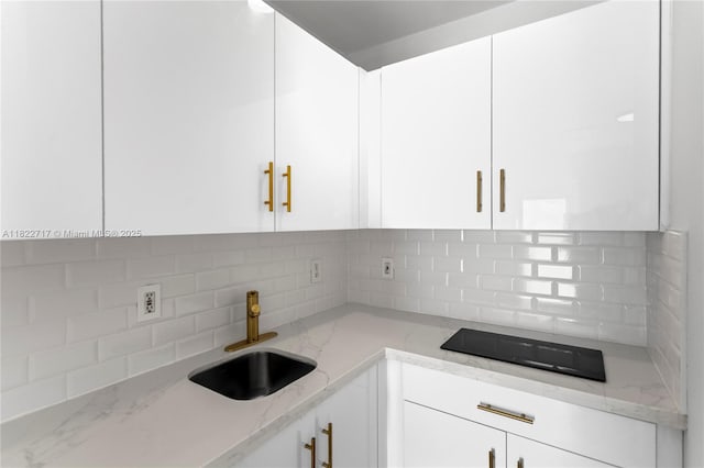 5401 Fillmore St, Hollywood, FL 33021 - kitchen with white cabinetry, tasteful backsplash, light stone counters, and black electric cooktop