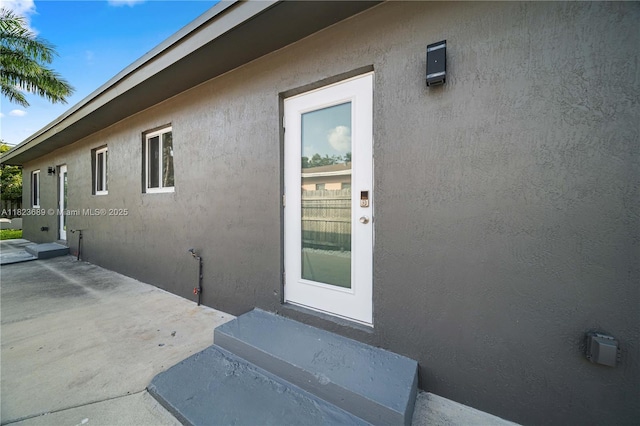 1250 NE 110th St, Miami, FL 33161 - view of exterior entry with stucco siding and a patio area