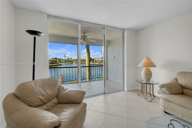 777 S Federal Hwy Unit 201G, Pompano Beach, FL 33062 - living room with a water view, a wall of windows, a ceiling fan, tile patterned floors, and a textured ceiling