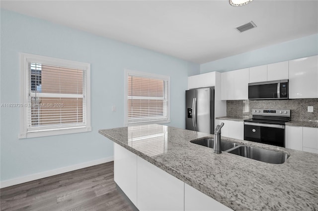 15452 SW 138th Ter, Miami, FL 33196 - kitchen with stainless steel appliances, white cabinetry, light stone countertops, and tasteful backsplash