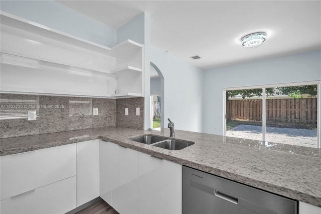 15452 SW 138th Ter, Miami, FL 33196 - kitchen with dishwasher, arched walkways, light stone counters, white cabinetry, and decorative backsplash
