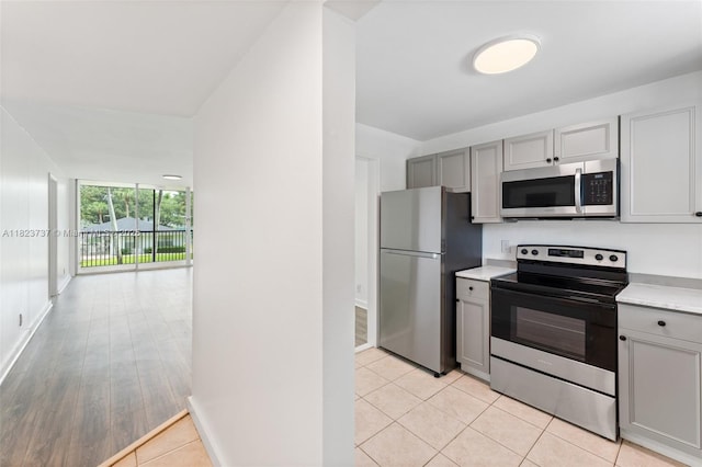 5100 SW 64th Ave Unit 204A, Davie, FL 33314 - kitchen with appliances with stainless steel finishes, gray cabinets, light countertops, and light tile patterned floors