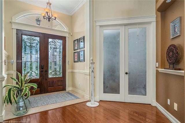 3859 Enchanted Oaks Ln, Sebring, FL 33875 - foyer with french doors, wood finished floors, a chandelier, and ornamental molding