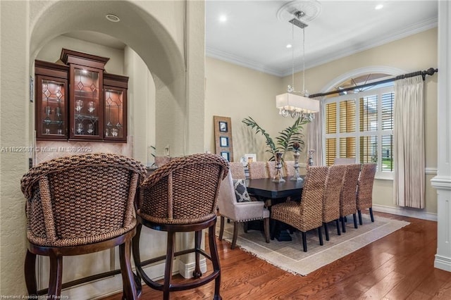 3859 Enchanted Oaks Ln, Sebring, FL 33875 - dining area with dark wood-style flooring, a chandelier, crown molding, arched walkways, and recessed lighting
