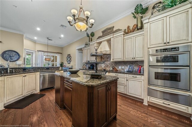 3859 Enchanted Oaks Ln, Sebring, FL 33875 - kitchen with a warming drawer, cream cabinets, appliances with stainless steel finishes, dark wood-style floors, and a chandelier
