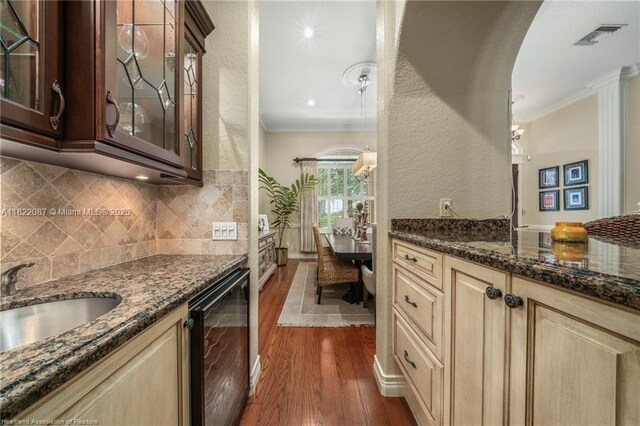 3859 Enchanted Oaks Ln, Sebring, FL 33875 - kitchen with wine cooler, ornamental molding, dark wood-type flooring, glass insert cabinets, and dark stone countertops