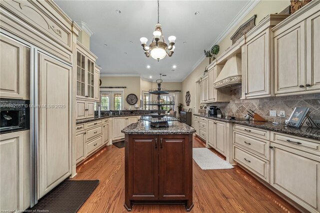 3859 Enchanted Oaks Ln, Sebring, FL 33875 - kitchen with cream cabinetry, premium range hood, crown molding, dark wood-style floors, and recessed lighting