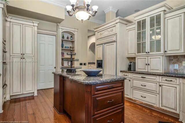 3859 Enchanted Oaks Ln, Sebring, FL 33875 - kitchen with cream cabinetry, paneled refrigerator, glass insert cabinets, backsplash, and ornamental molding