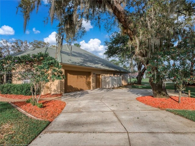 3859 Enchanted Oaks Ln, Sebring, FL 33875 - view of side of home with concrete driveway, stucco siding, and a garage