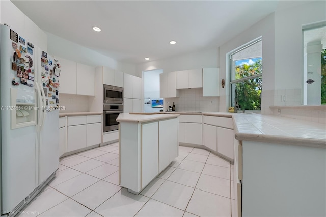 6670 SW 69th Ln, South Miami, FL 33143 - kitchen featuring appliances with stainless steel finishes, tasteful backsplash, white cabinets, recessed lighting, and a kitchen island