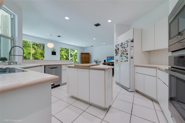6670 SW 69th Ln, South Miami, FL 33143 - kitchen with appliances with stainless steel finishes, white cabinetry, recessed lighting, and a kitchen island
