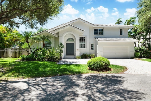 6670 SW 69th Ln, South Miami, FL 33143 - mediterranean / spanish home featuring driveway, a tiled roof, an attached garage, and stucco siding