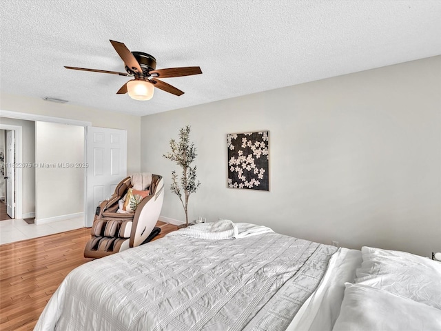 3920 NW 20th St, Coconut Creek, FL 33066 - bedroom featuring a textured ceiling, light wood-style flooring, and ceiling fan