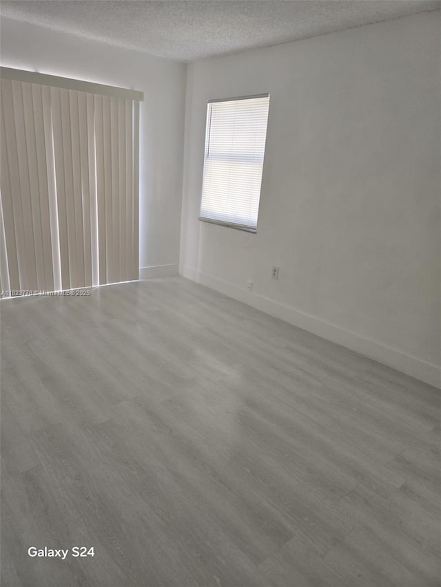 1000 W 28th St Unit 17, Hialeah, FL 33010 - empty room with wood finished floors and a textured ceiling
