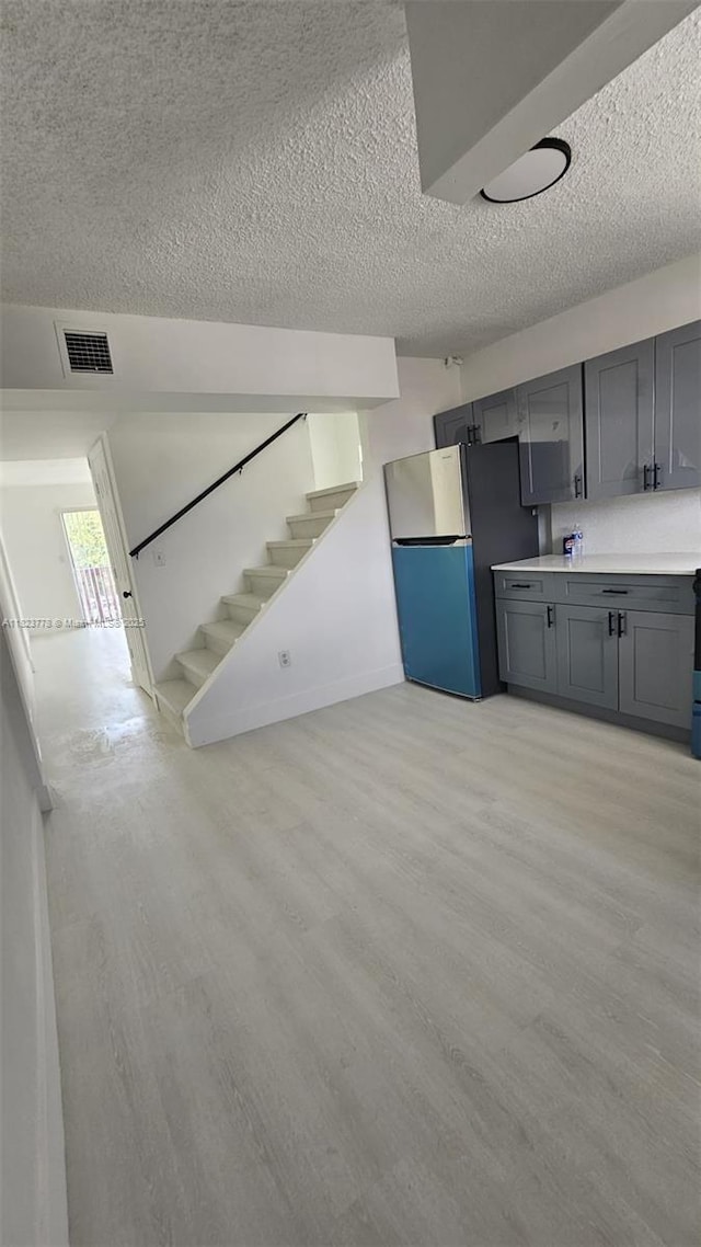 1000 W 28th St Unit 17, Hialeah, FL 33010 - kitchen featuring freestanding refrigerator, a textured ceiling, gray cabinets, light wood finished floors, and light countertops