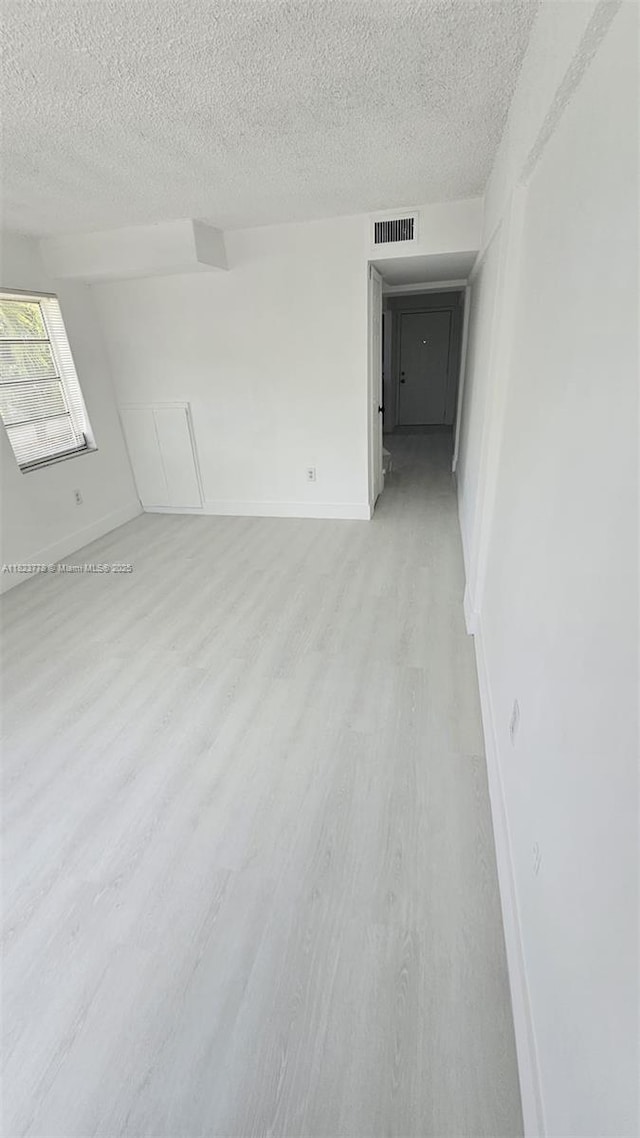 1000 W 28th St Unit 17, Hialeah, FL 33010 - empty room featuring light wood finished floors and a textured ceiling