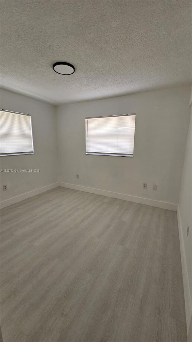 1000 W 28th St Unit 17, Hialeah, FL 33010 - spare room featuring a textured ceiling, wood finished floors, and plenty of natural light