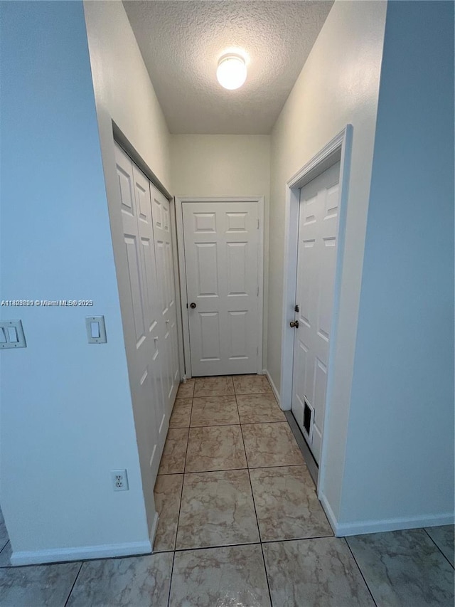 185 Riverwalk Cir, Sunrise, FL 33326 - hallway featuring a textured ceiling and baseboards