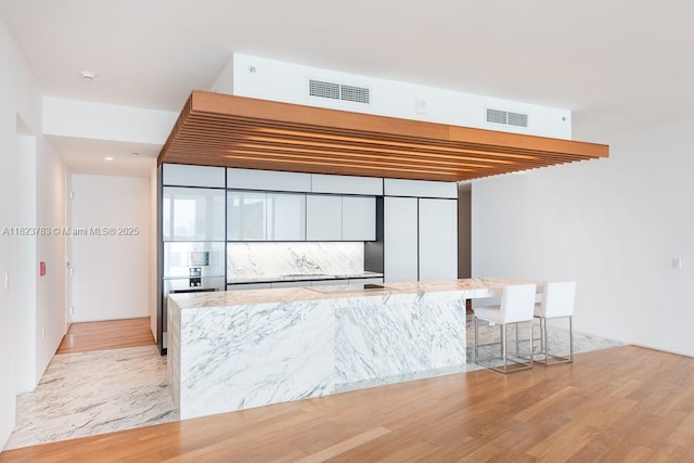 1300 Monad Ter Unit 9D, Miami Beach, FL 33139 - kitchen featuring light stone countertops and light wood-type flooring
