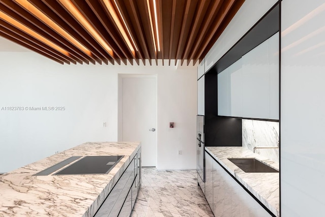 1300 Monad Ter Unit 9D, Miami Beach, FL 33139 - kitchen with black electric stovetop, modern cabinets, light stone counters, and oven