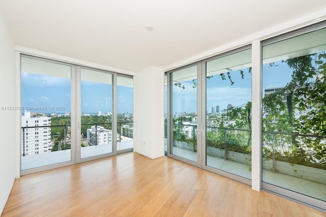 1300 Monad Ter Unit 9D, Miami Beach, FL 33139 - empty room featuring floor to ceiling windows, a view of city, and wood finished floors