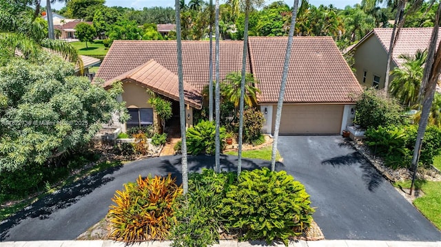 1180 NW 100th Way, Plantation, FL 33322 - view of front of property featuring a tile roof, stucco siding, a garage, and asphalt driveway