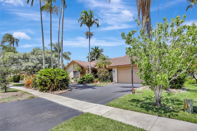 1180 NW 100th Way, Plantation, FL 33322 - obstructed view of property featuring driveway, an attached garage, stucco siding, and a tiled roof