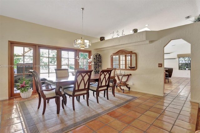 1180 NW 100th Way, Plantation, FL 33322 - dining space featuring a chandelier, plenty of natural light, light tile patterned floors, and arched walkways