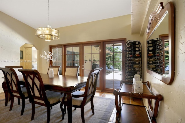 1180 NW 100th Way, Plantation, FL 33322 - dining area featuring a chandelier, a textured wall, arched walkways, and french doors