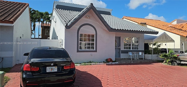 8881 NW 108th Ln, Hialeah Gardens, FL 33018 - rear view of property featuring a tiled roof, stucco siding, and a patio