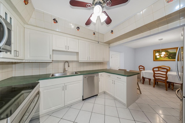 359 E 19th St, Hialeah, FL 33010 - kitchen with appliances with stainless steel finishes, ceiling fan, dark countertops, a peninsula, and white cabinets